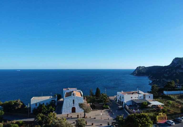 Church of Es Cubells in Ibiza with cliffs and sea in the background