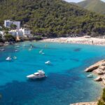 Cala Llonga Beach with wide sandy shores and clear waters in Ibiza.
