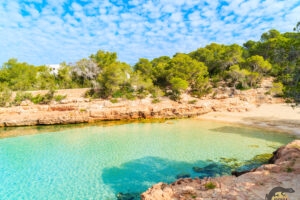 Cala Gració Beach with golden sands and clear blue water in Ibiza.