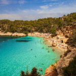 View of Cala Saladetta beach with crystal-clear waters and rocky surroundings in Ibiza