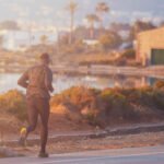 Runner on Ibiza trail with panoramic sea views.