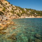 Rustic fishermen huts on the secluded shore of Cala Llentrisca, Ibiza